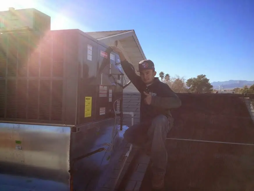 HVAC technician performing AC Tune-Up on a rooftop unit in Madeira